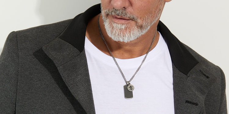 Eleganter Mann präsentiert silberne Herrenkette mit modernem Anhänger - stilvoller Männerschmuck